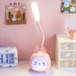 Pink bunny rabbit LED night light for girls displayed on a table next to a clock.