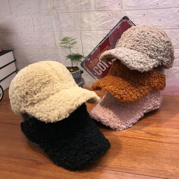 A stylish faux fur cap for girls displayed on a table, showing its trendy and cosy design in a home setting.