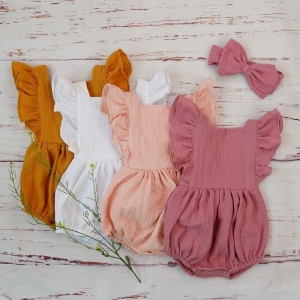 A fashionable girls playsuit with matching bow headband displayed on a table, a fun and stylish summer outfit.