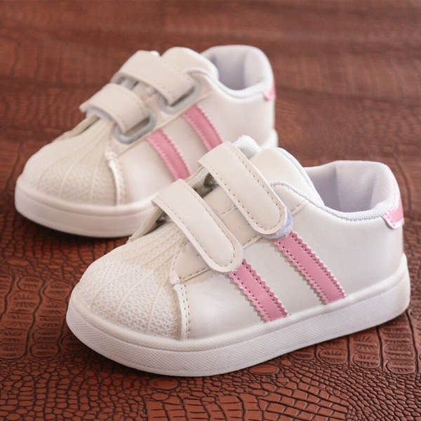 A pair of casual and stylish girls' trainers displayed in a home setting, combining comfort with trendy design