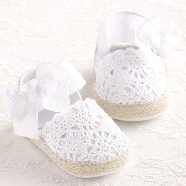 Charming knitted ballet flats with a bow for girls, shown on a rug — stylish and cosy for little feet.