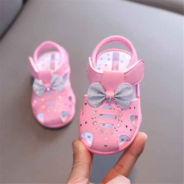 Side view of the girls glitter bow sandals, showcasing the shimmering bow detail and stylish sandal design.