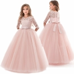 A young girl wearing a beautiful pink lace and tulle party dress with three-quarter sleeves and bow detail, shown from front and back.