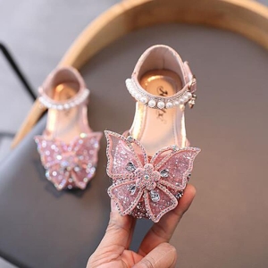Sandales d'été à paillettes pour petites filles sur un chaise