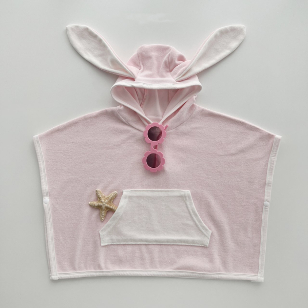 Pink hooded baby bath robe with bunny ears, front pockets, and a starfish decoration, with sunglasses at the collar