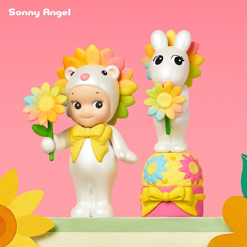 Two Sonny Angel floral theme figurines on their display boxes surrounded by flowers, beautifully styled to show the delicate and colourful floral designs.