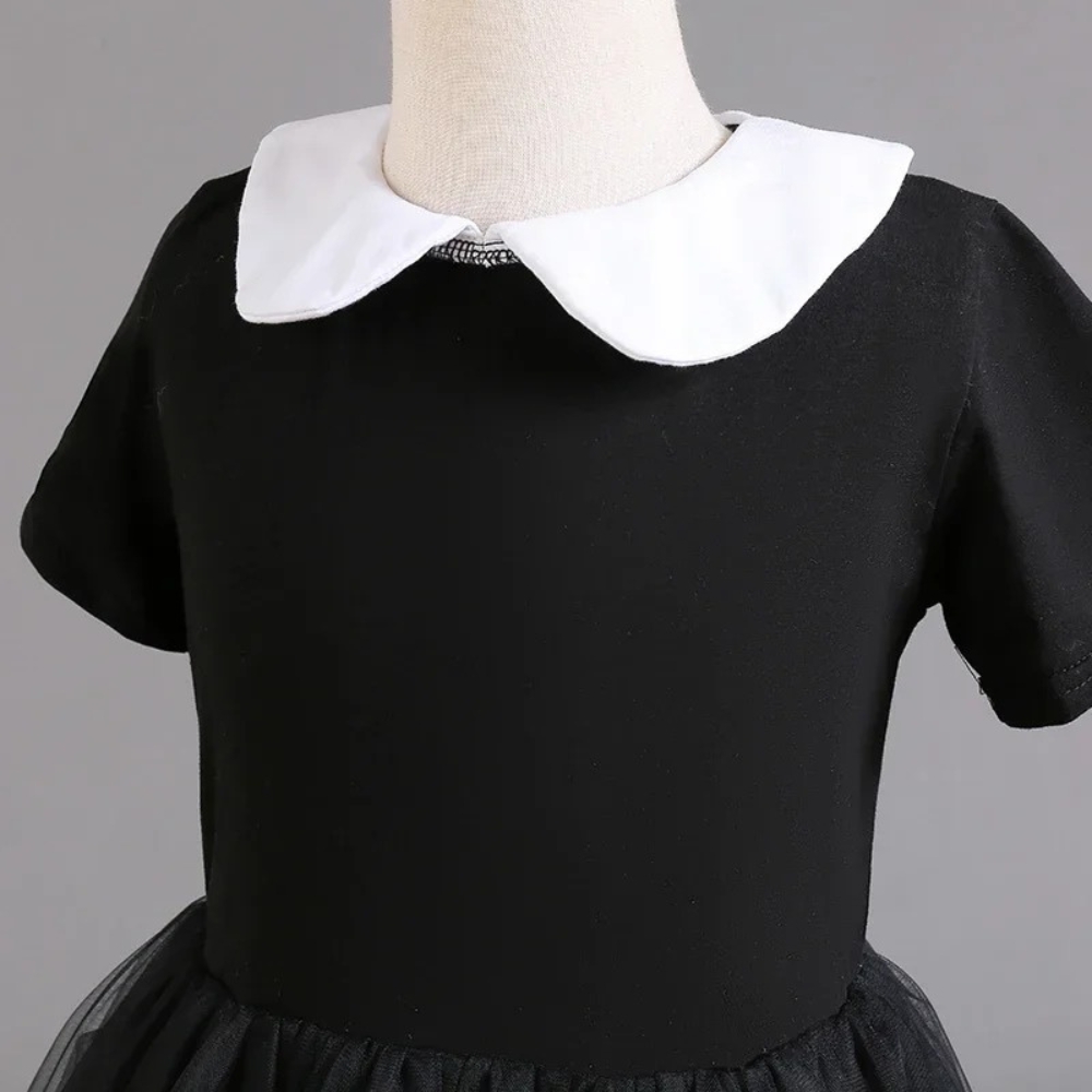 Full view of the Wednesday Addams Halloween fancy dress for girls, showcasing the complete gothic-inspired black dress and white collar that recreates her iconic and mysterious style.