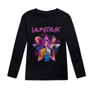 T-shirt fille K-pop Demon Hunters à manches longues avec motif coloré. Le t-shirt est noir. Le motif met à l'honneur les trois héroïnes du film avec le nom de leur groupe au-dessus en lettres majuscules violettes "HUNTRIX". Sur fond blanc.