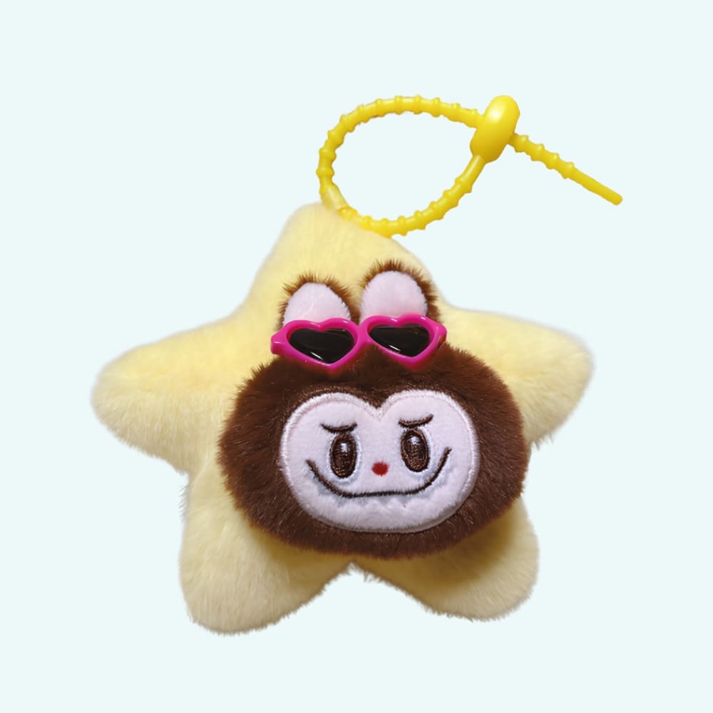 Yellow star-shaped Labubu-style plush keyring with a brown Labubu face wearing pink heart-shaped sunglasses, with a yellow attachment clip, on a sky blue background.