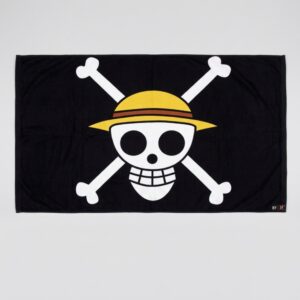 Black One Piece flag featuring Luffy's iconic skull emblem in white, displayed against a grey background, perfect for a fan's bedroom.
